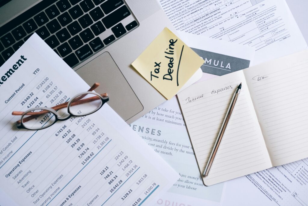 pexels-photo-8962476-8962476 Workspace with laptop, documents, and tax deadline note for financial management.